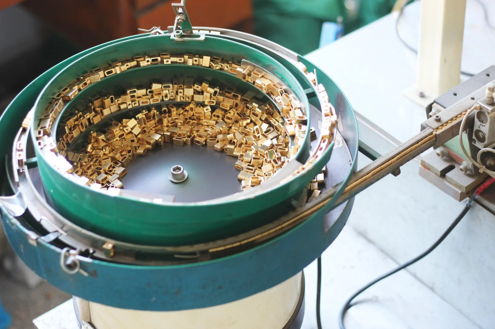 Vibratory bowl feeder with brass contact parts